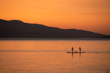 Fototapeta na wymiar Paddle Boarding at Sunset 