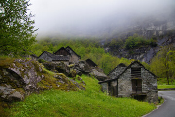 Fototapeta na wymiar Stone houses an Waterfall Val Bavona, Cevio in Switzerland spring 2021