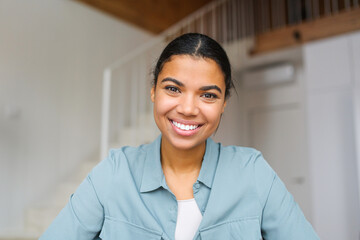 Close-up portrait of happy young woman looking at the camera and smiling. Concept of video call,...