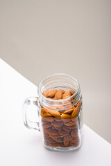 Glass jar filled with a variety of nutrition and healthy snacks and nuts on a dark background