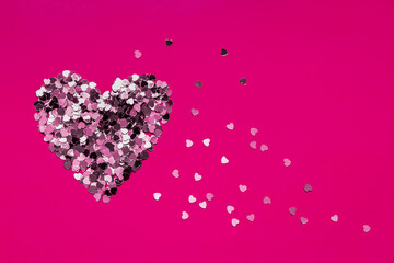 Obraz premium Valentine's Day heart made of confetti on a dark pink background. Copy space