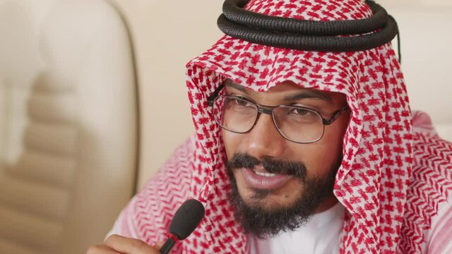 Close up of Arab political leader in keffiyeh talking in microphone during press conference, addressing to audience