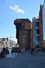 Obraz premium The famous Krantor, city gate with tourists in Danzig, Gdansk, Poland in summer with blue sky