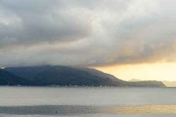 Panorama shots of gorgeous sunset over the Pacific Ocean with puffy rain clouds in the background. 