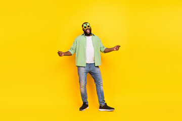 Full length photo of cheerful glad young guy dancing spend free time weekend club isolated on yellow color background