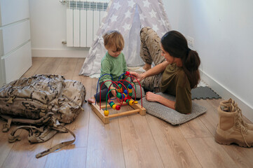 Military mother and son playing with toy