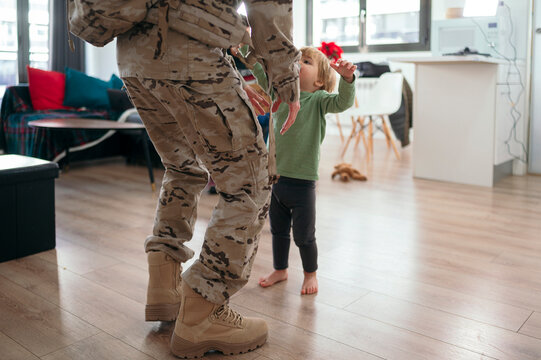 Son hugging faceless military parent