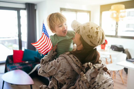Faceless military woman with son in arms