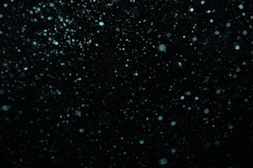 Dark bokeh background with snow. Copy space
