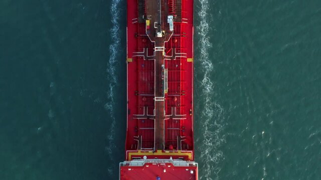 Red crude oil tanker Ship cruising at sea, Aerial view.