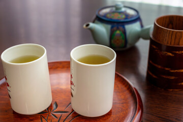 白いコップに注がれた緑茶