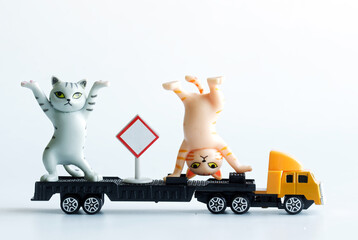 Two toy kittens show circus acrobatic performances on a truck with a trailer. The concept of a...