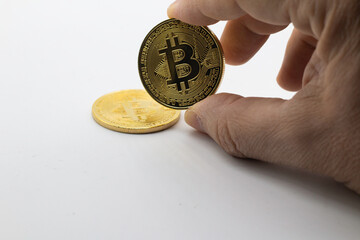 Man examines virtual bitcoin image in gold color