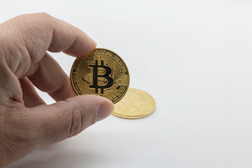 Man examines virtual bitcoin image in gold color