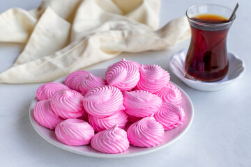 Small pink meringues in a white dish. Macro shot. Horizontal view