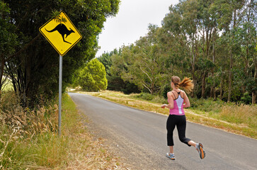 Female jogger on country road and kangaroo sign Australia