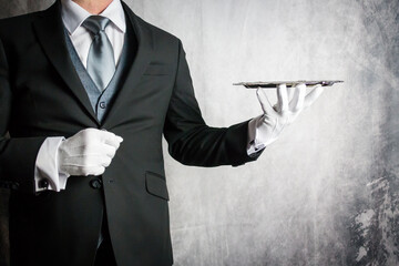 Portrait of Butler or Waiter in Dark Suit and White Gloves Holding Silver Serving Tray. Copy Space...
