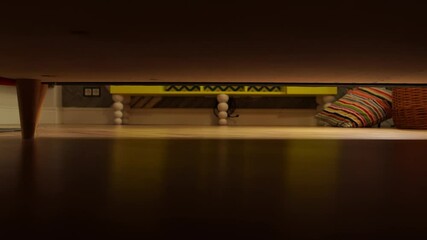 A panoramic view of the cat hunting on the owner legs from under the bed