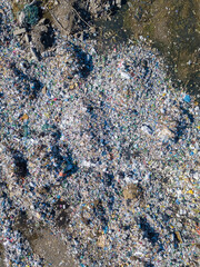 Drone view of a large landfill, a pile of garbage. Household waste in a landfill, waste disposal in a landfill. Concept of ecology, consumerism. Vertical photo
