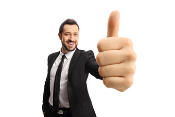 Happy businessman gesturing a thumb up sign in front of camera