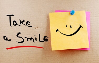 Take a smile handwritten note on a cork board