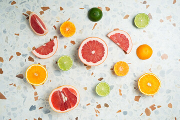 Fruit background. Colorful fresh fruits on terrazzo table. Orange, tangerine, lime, lemon, grapefruit. Flat lay, top view, copy space