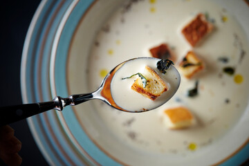 Cream soup close-up on a spoon
