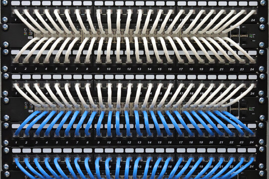 Connecting Ethernet switches to patch panels using colored patch cords in the data center.