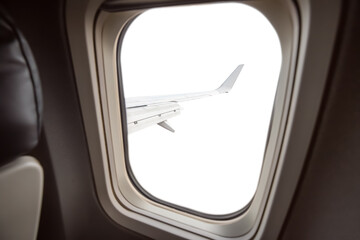 Isolated and cutout on white view from the passenger seat to the porthole and the wing of the aircraft.