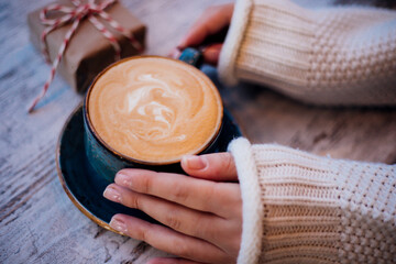 Women's hands are holding a cup of coffee. The atmosphere of a cozy evening. gifts for Christmas and new year.