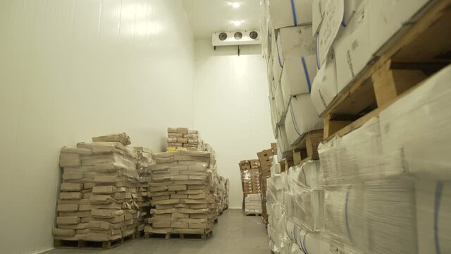 Boxes of groceries in a industrial food large cold storage safety refrigerators. Panoramic shot. Slow Motion