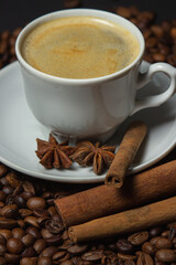 A cup of espresso coffee with cinnamon, coffee beans around. Natural coffee with additives. Invigorating drink