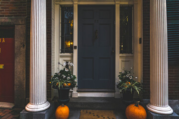 View of a apartment exterior door and decoration of plants and pumpkins for Thanksgiving. Stoop...