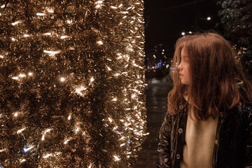 portrait of teenage girl at night with christmas illumination