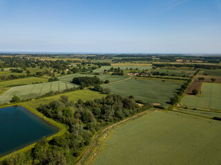Aerial view of a patchwork of farm fields in the Suffolk countryside with a large reservoir in the...