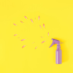 Creative romantic look of spray and violet petals on a light yellow background. Minimal flower concept