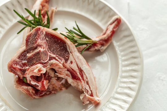 Raw lamb chops on plate