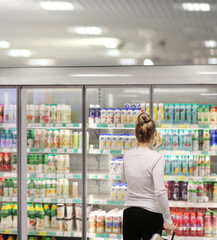 Woman choosing frozen food from a supermarket freezer.