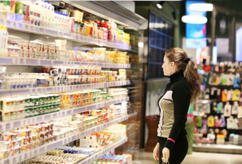 Woman choosing a dairy products at supermarket