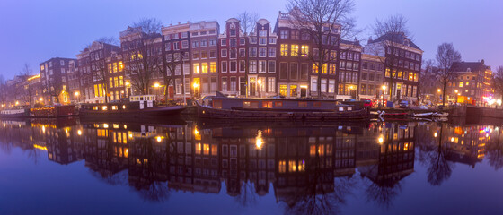 Naklejka premium Panorama of the city waterfront of Amsterdam at sunset.