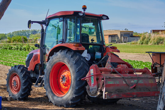 Elegant Red Tractor with cutter on the field