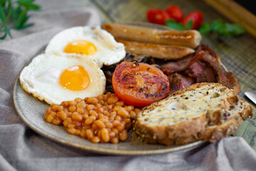 English Breakfast close up. Eggs, beans, sausages, mushrooms, bacon, tomato and toast.