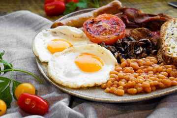 English Breakfast close up. Eggs, beans, sausages, mushrooms, bacon, tomato and toast.
