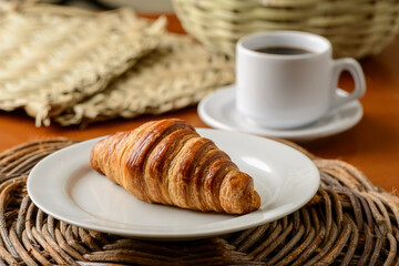 Croissant on white plate for breakfast.