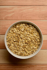 Oatmeal in white bowl on wooden table.