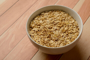 Oatmeal in white bowl on wooden table.