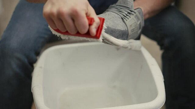 Man washing dirty shoes with a brush