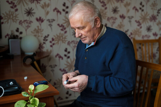 Senior man with lancet device