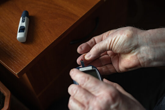Anonymous person piercing finger to check blood sugar