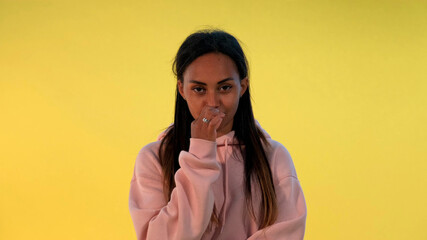 Portrait of african woman's lips closing zipper on yellow background. It must be secret.